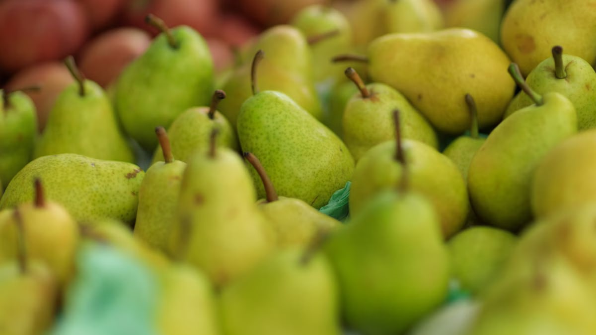 Close-up of ripe green pears at a market stall. Perfect for healthy lifestyle themes.